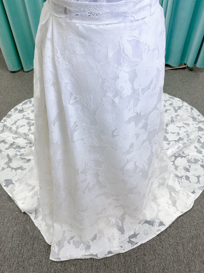 Willow ivory off-the-shoulder floral jacquard A-line wedding dress on mannequin with full skirt and front slit.
