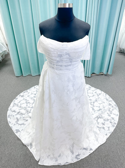 Willow ivory off-the-shoulder floral jacquard A-line wedding dress on mannequin with full skirt and front slit.
