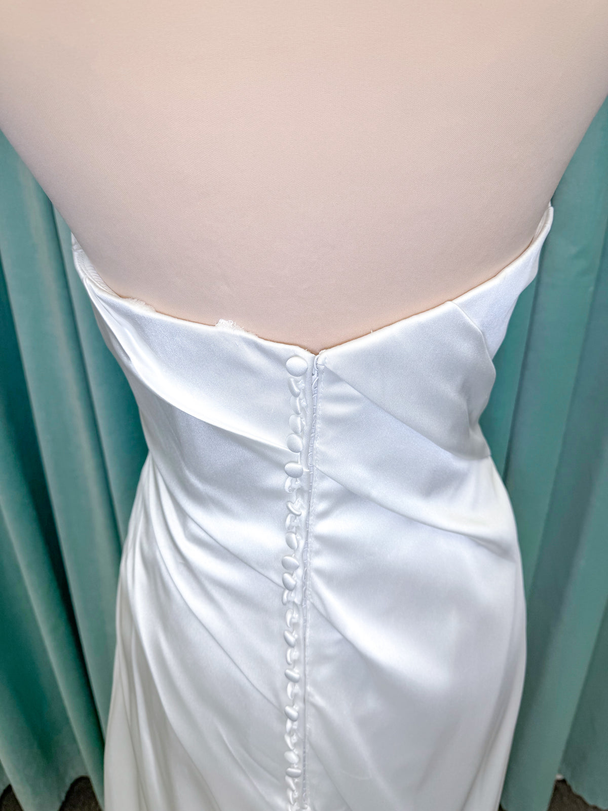 Morilee 2941 Zenobia fit and flare wedding dress on mannequin with strapless scoop neckline, asymmetric draped satin, and skirt slit
