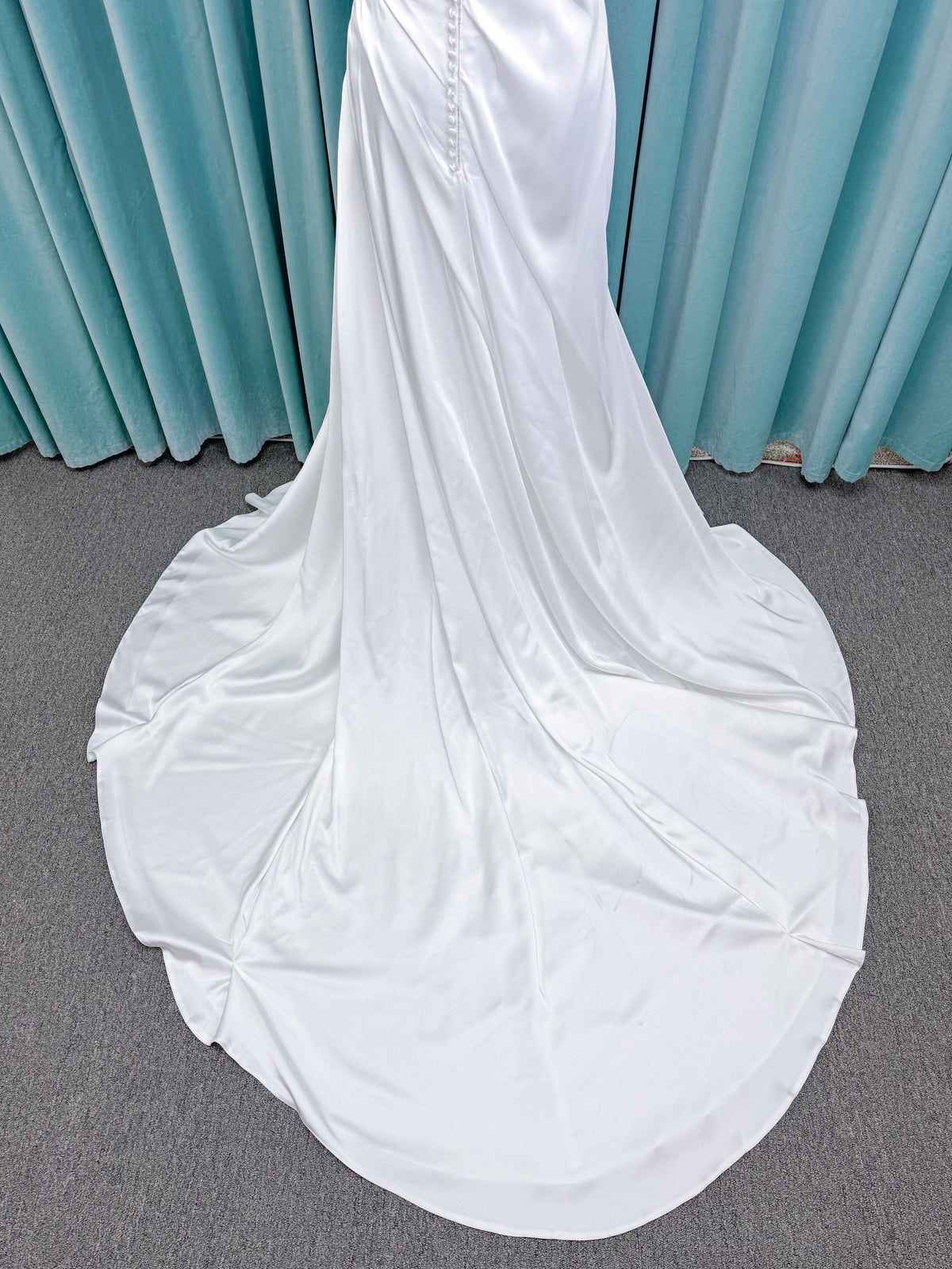 Morilee 2941 Zenobia fit and flare wedding dress on mannequin with strapless scoop neckline, asymmetric draped satin, and skirt slit