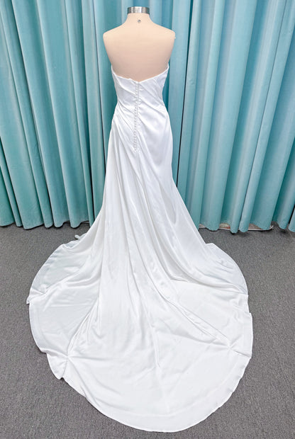 Morilee 2941 Zenobia fit and flare wedding dress on mannequin with strapless scoop neckline, asymmetric draped satin, and skirt slit