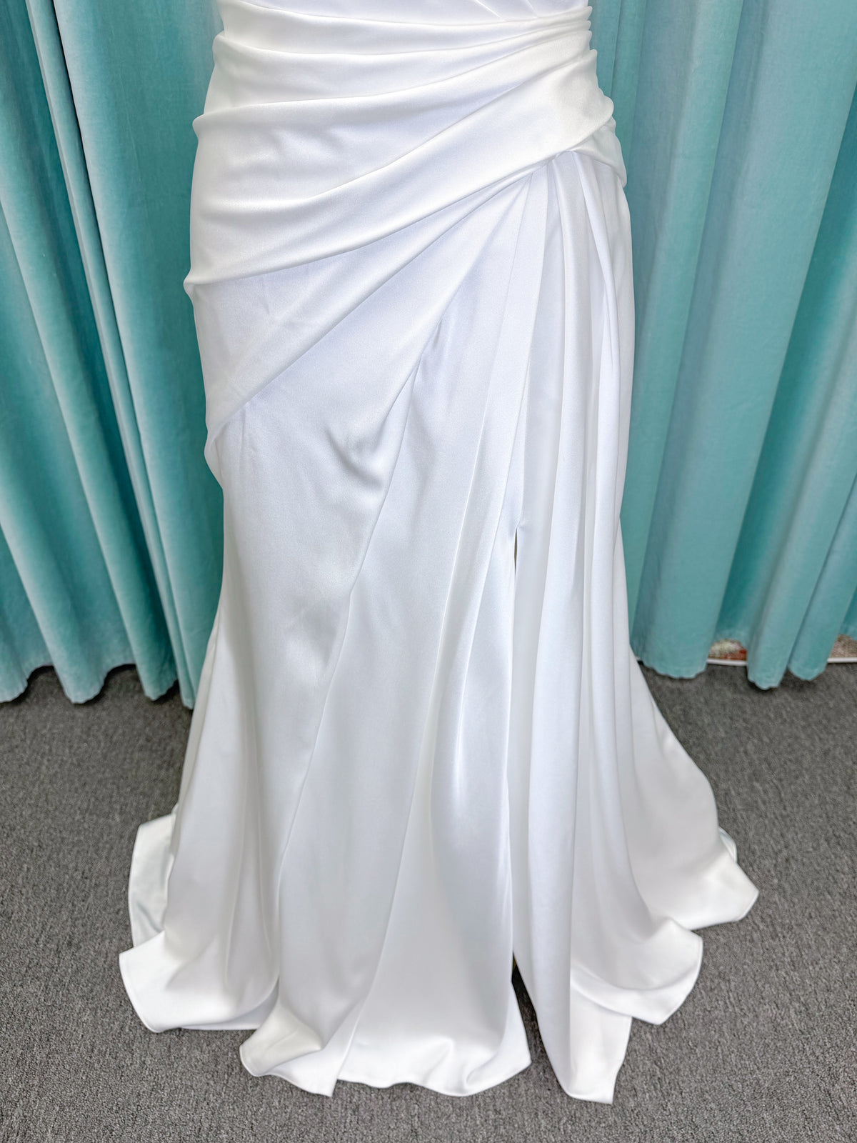 Morilee 2941 Zenobia fit and flare wedding dress on mannequin with strapless scoop neckline, asymmetric draped satin, and skirt slit