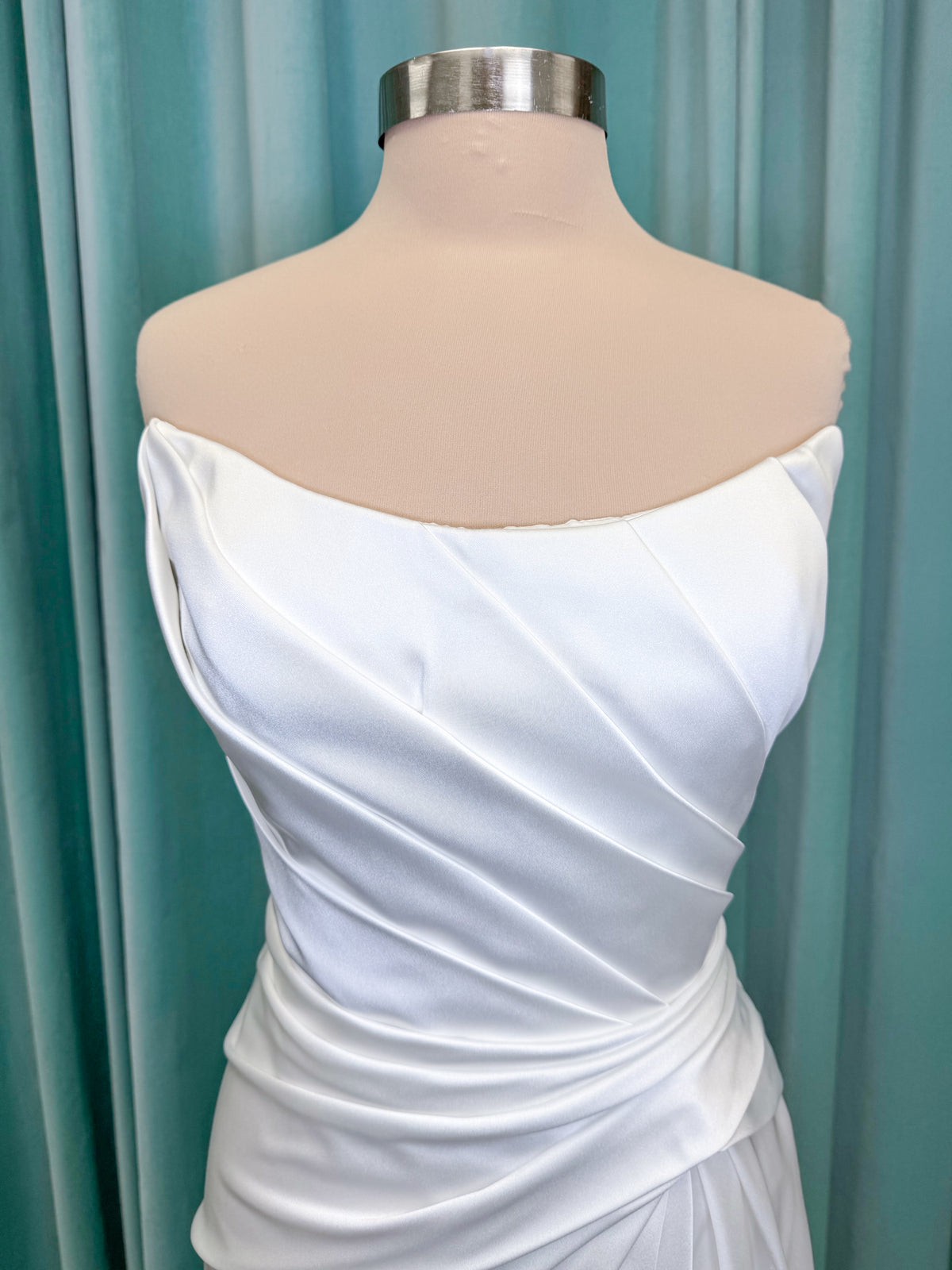 Morilee 2941 Zenobia fit and flare wedding dress on mannequin with strapless scoop neckline, asymmetric draped satin, and skirt slit