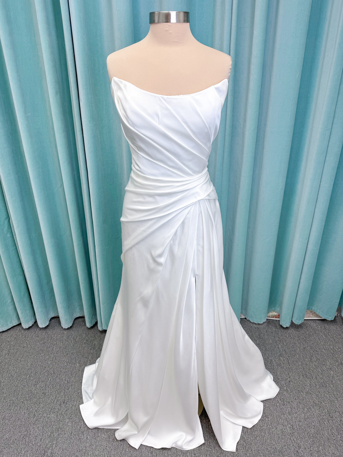 Morilee 2941 Zenobia fit and flare wedding dress on mannequin with strapless scoop neckline, asymmetric draped satin, and skirt slit