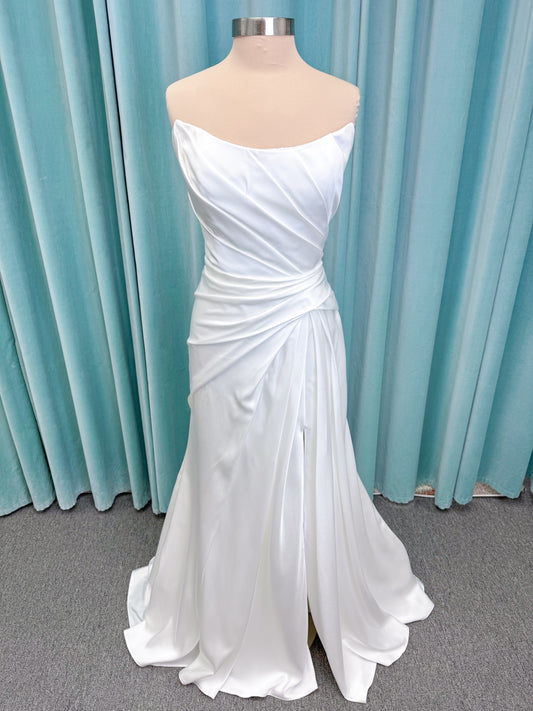 Morilee 2941 Zenobia fit and flare wedding dress on mannequin with strapless scoop neckline, asymmetric draped satin, and skirt slit