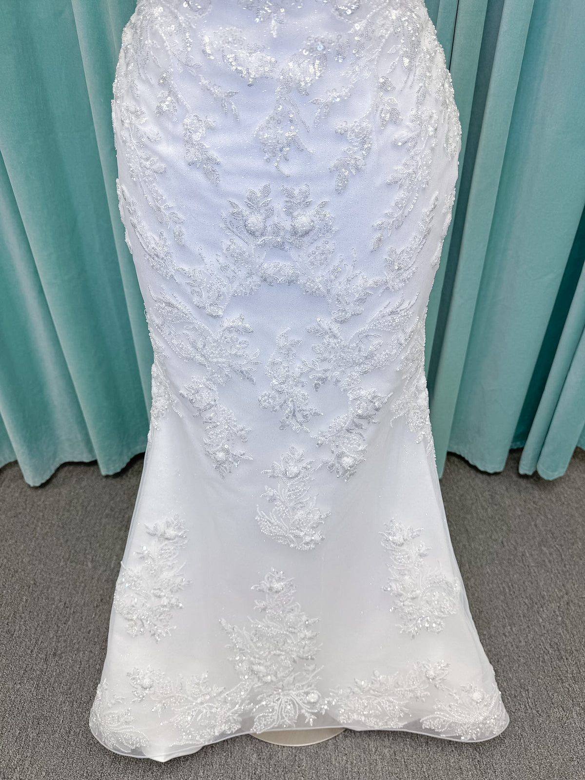 Moonlight Bridal J6996 Zira mermaid wedding dress on mannequin with strapless pointed sweetheart illusion neckline, side bodice cutouts, beaded lace appliques on shimmer net, drop waist, and chapel train with horsehair trim