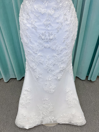 Moonlight Bridal J6996 Zira mermaid wedding dress on mannequin with strapless pointed sweetheart illusion neckline, side bodice cutouts, beaded lace appliques on shimmer net, drop waist, and chapel train with horsehair trim