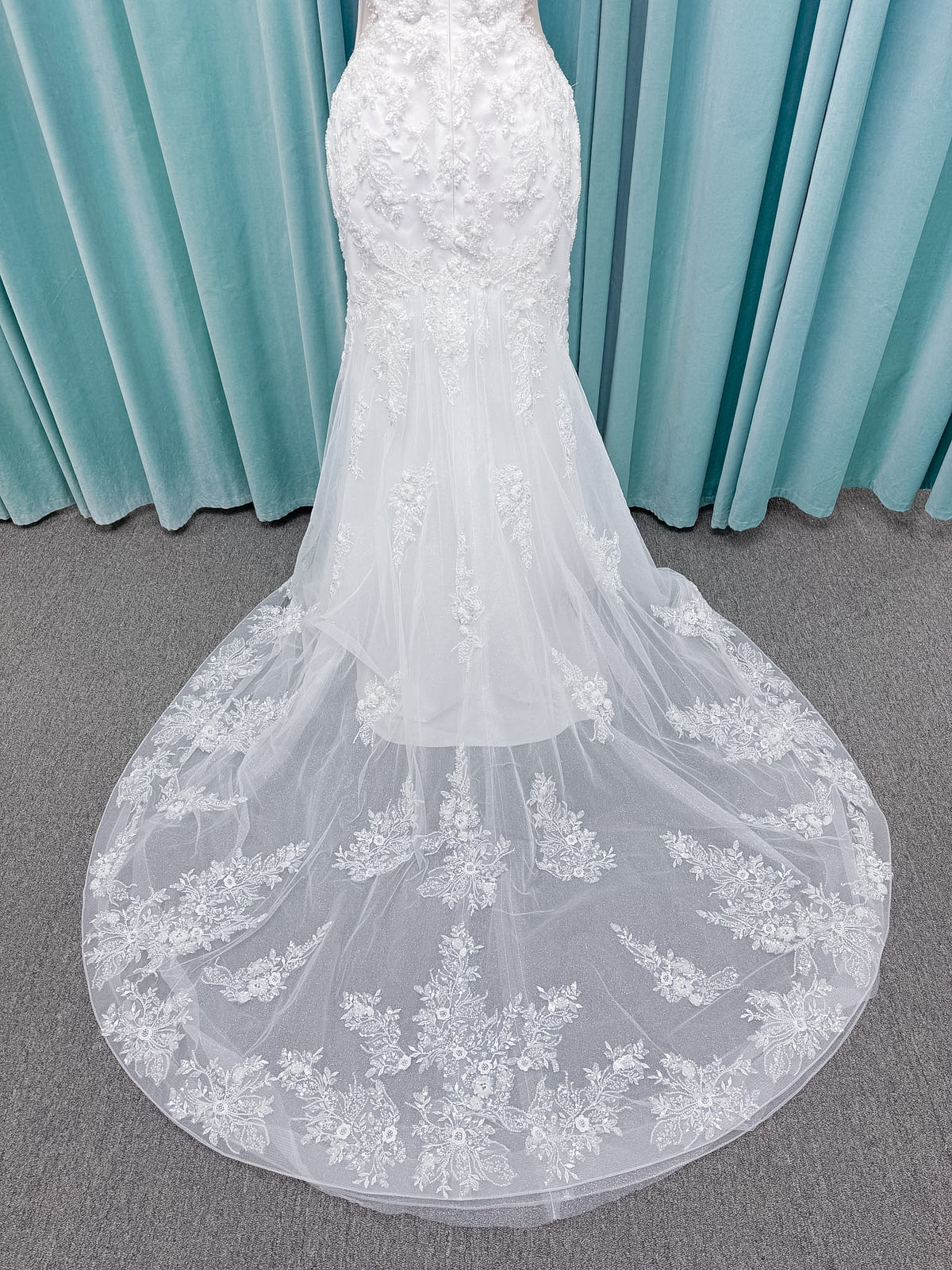 Moonlight Bridal J6996 Zira mermaid wedding dress on mannequin with strapless pointed sweetheart illusion neckline, side bodice cutouts, beaded lace appliques on shimmer net, drop waist, and chapel train with horsehair trim