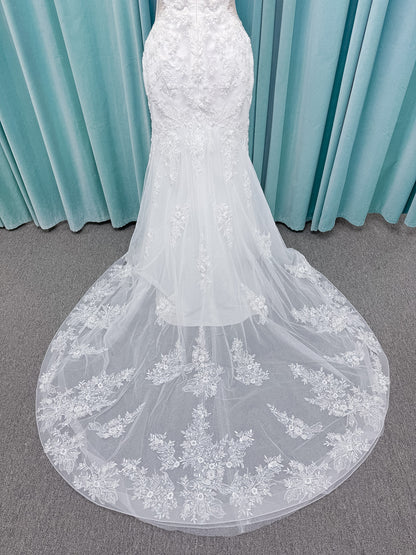 Moonlight Bridal J6996 Zira mermaid wedding dress on mannequin with strapless pointed sweetheart illusion neckline, side bodice cutouts, beaded lace appliques on shimmer net, drop waist, and chapel train with horsehair trim