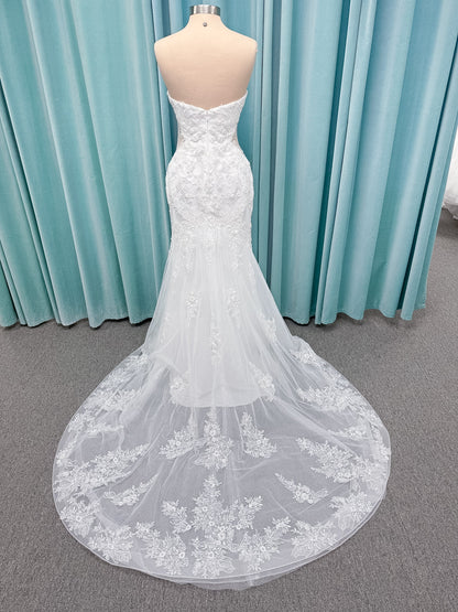 Moonlight Bridal J6996 Zira mermaid wedding dress on mannequin with strapless pointed sweetheart illusion neckline, side bodice cutouts, beaded lace appliques on shimmer net, drop waist, and chapel train with horsehair trim