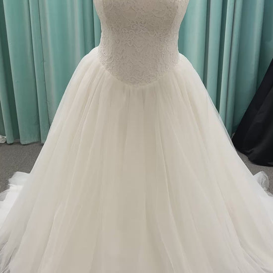 Plus size strapless lace ballgown wedding dress with cat-eye neckline, basque waist, full tulle skirt, and detachable satin bow by Stella York Style SY8189