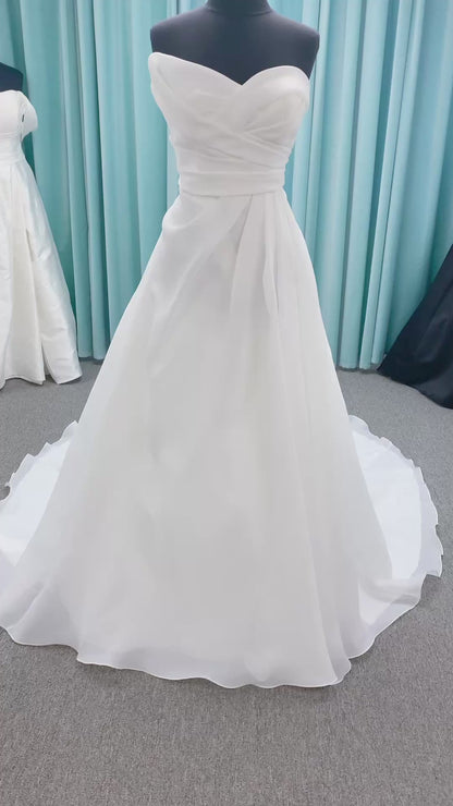 Morilee 2989 Helenia contemporary strapless A-line wedding dress in draped organza with detachable bow and sweeping train.