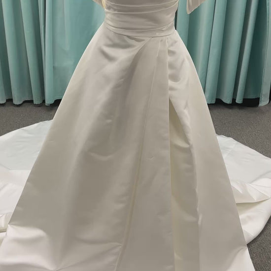 Off-the-shoulder satin A-line wedding dress with detachable straps, leg slit, pockets, and embroidered floral detailing by Essense of Australia style D4187