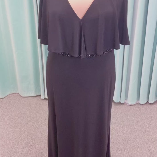 Morilee MLNY 73124 sheath mother of the bride dress on mannequin with V-neckline, flowing capelet overlay, crystal beaded waistband, and slim jersey sheath skirt
