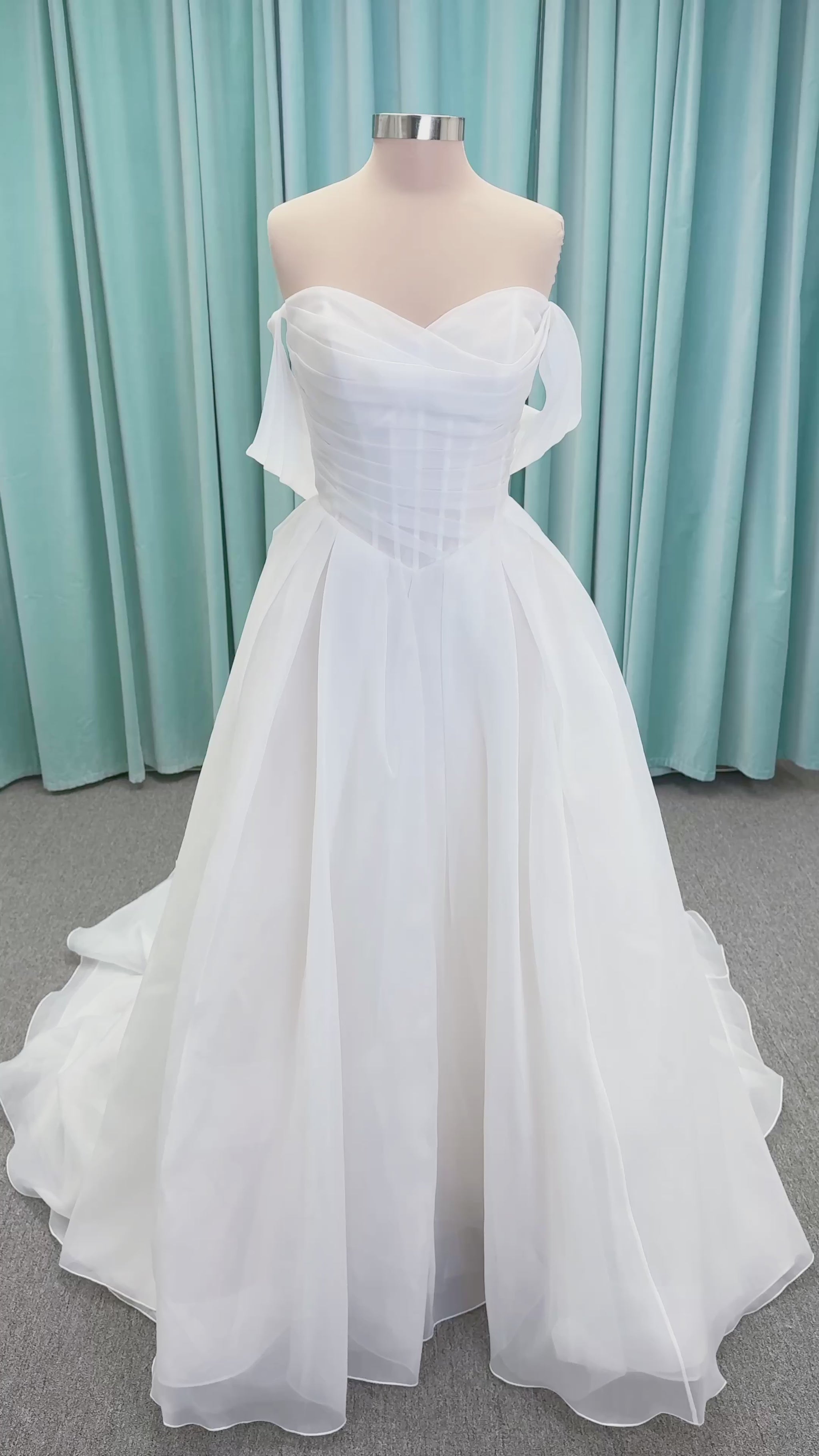 Morilee 2947L Damara A-line wedding dress on mannequin with modified sweetheart neckline, off-the-shoulder detailing, organza box pleats, and corset back