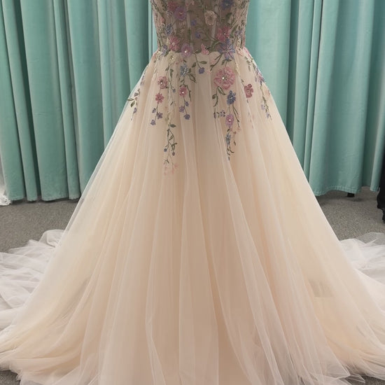 Stella York 8063 ivory and pastel colorful embroidered lace A-line wedding dress on mannequin with floral spaghetti straps, scoop neckline, and soft tulle skirt.
