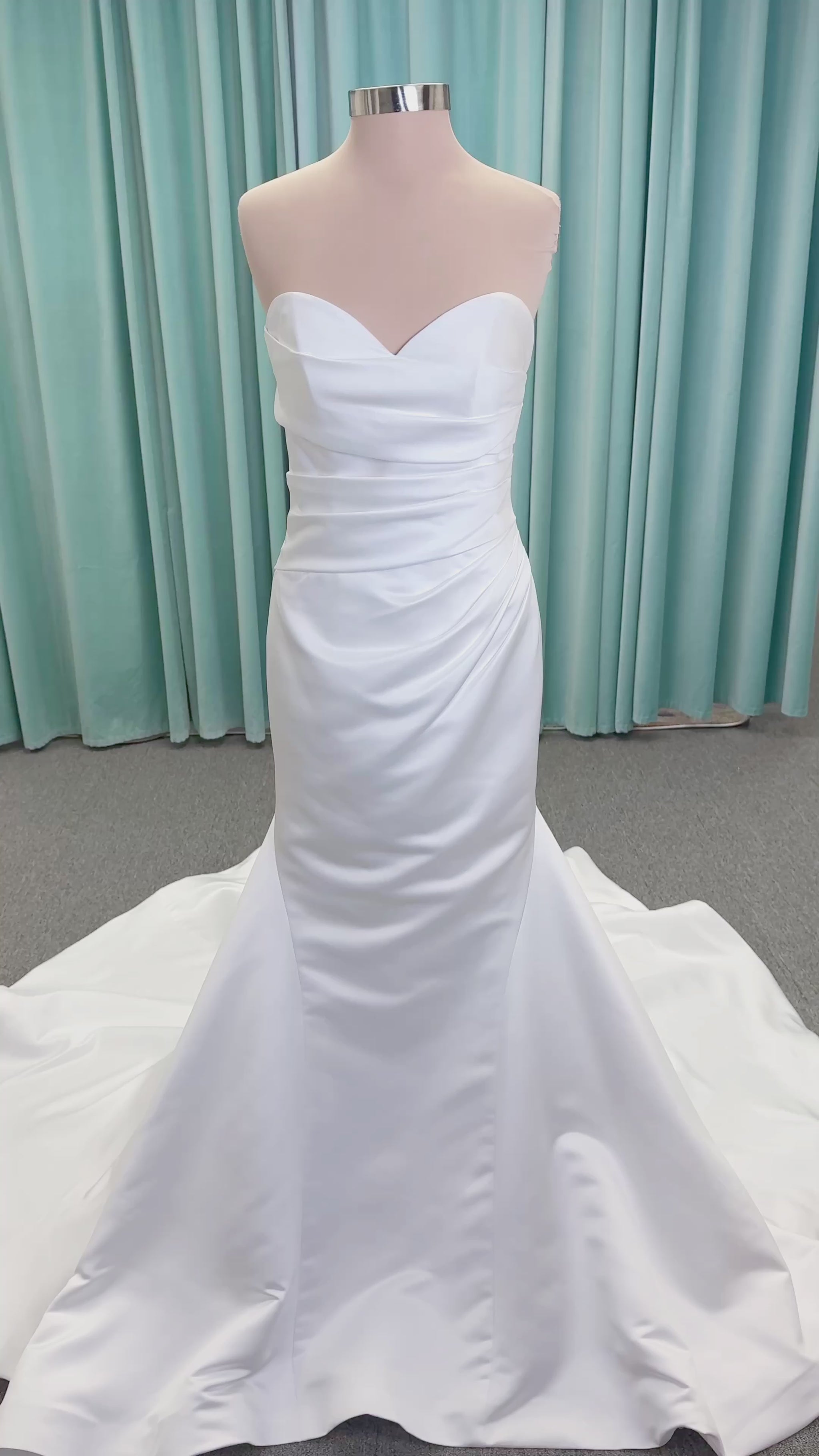 Strapless satin fit-and-flare wedding dress with sweetheart neckline, ruched bodice, fitted hips, and flared chapel-length train.