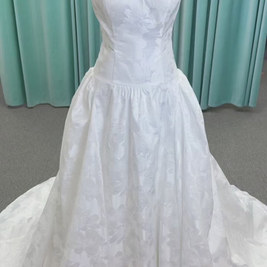 Moonlight Bridal J6994 Marama ballgown wedding dress on mannequin with strapless scoop neckline, textured satin jacquard, fitted drop-waist bodice, detachable short bow sleeves, full skirt, and sweep train