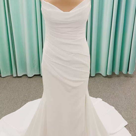 Stella York SY8224 sheath wedding dress on mannequin with spaghetti straps, draped scoop neckline, ruched crepe bodice, front slit, and detachable back cowl