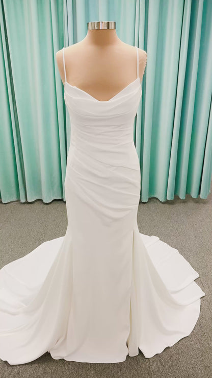 Stella York SY8224 sheath wedding dress on mannequin with spaghetti straps, draped scoop neckline, ruched crepe bodice, front slit, and detachable back cowl