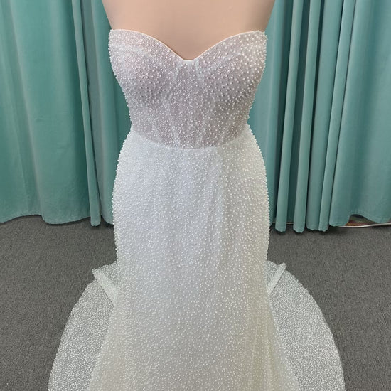Cynthia ivory strapless fit-and-flare wedding dress on mannequin with pearl-beaded corset bodice and sweetheart neckline.
