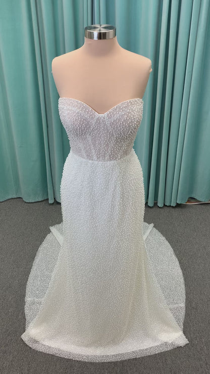 Cynthia ivory strapless fit-and-flare wedding dress on mannequin with pearl-beaded corset bodice and sweetheart neckline.
