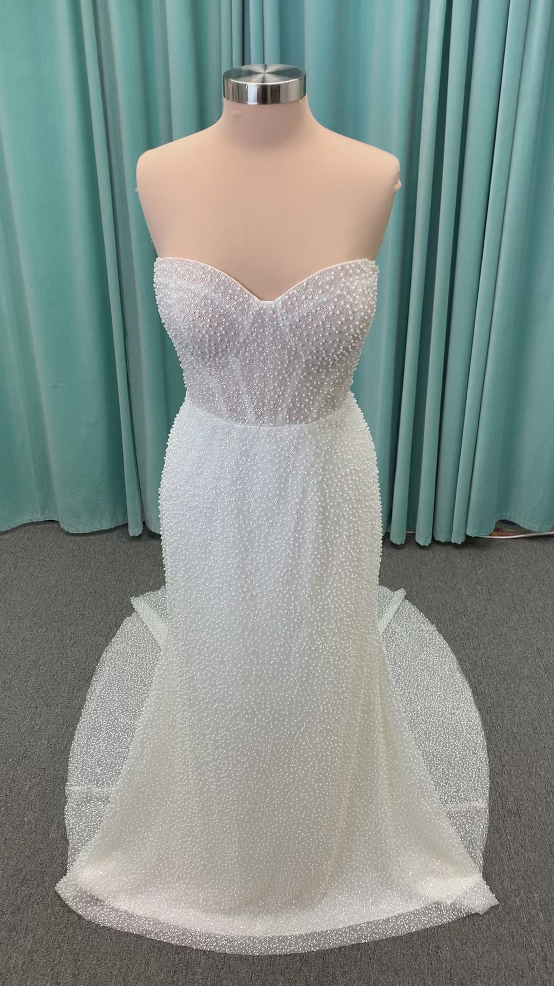 Cynthia ivory strapless fit-and-flare wedding dress on mannequin with pearl-beaded corset bodice and sweetheart neckline.
