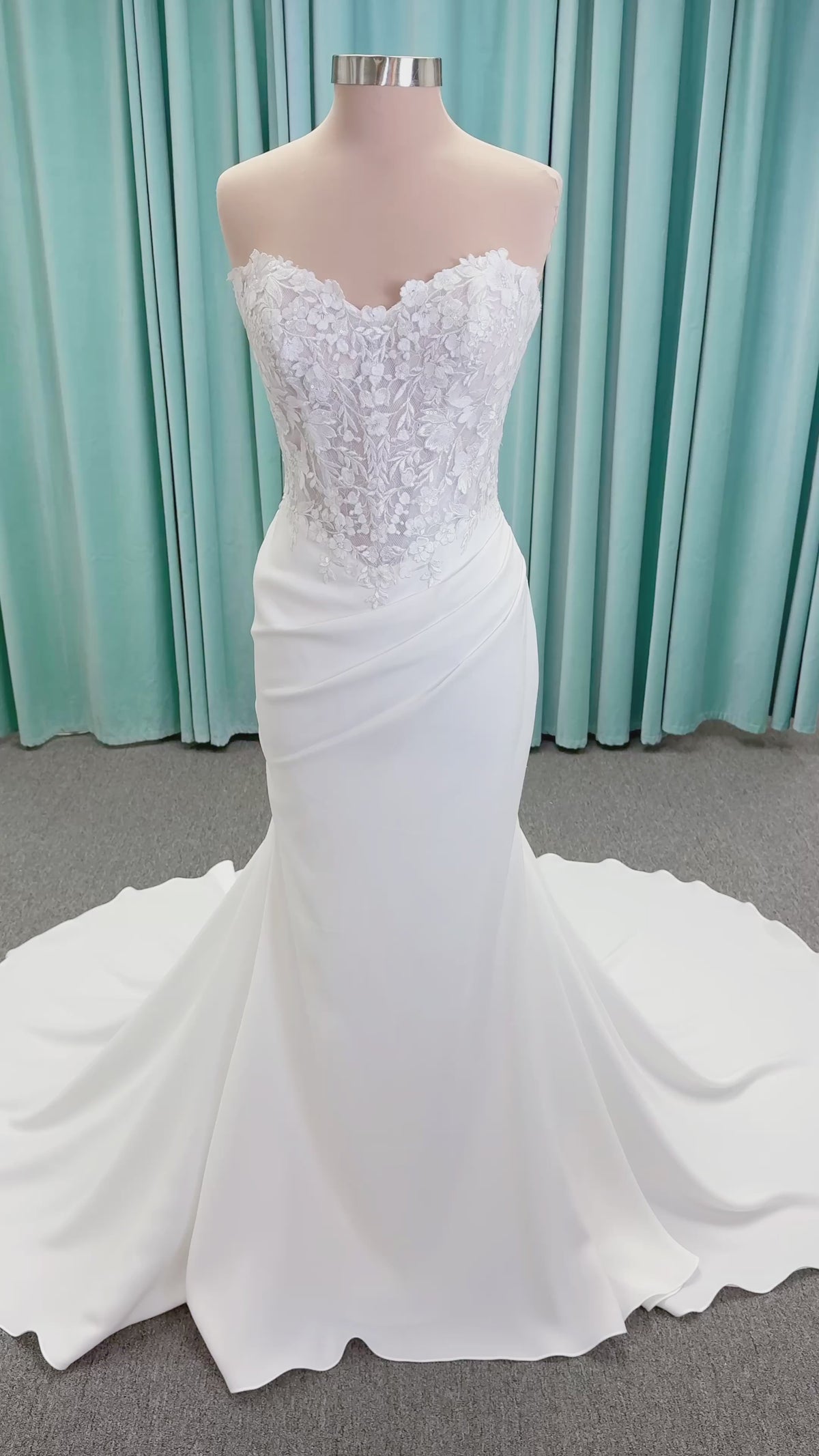 Randy Fenoli Kitty fit and flare wedding dress on mannequin with strapless sweetheart neckline, floral lace appliqué, and fluid crepe skirt