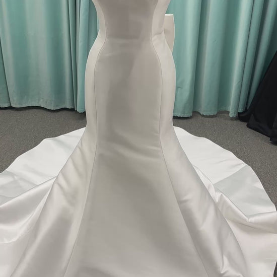 Strapless Mikado fit-and-flare wedding dress with sweetheart neckline, bow waist detail, and dramatic flared train by Stella York