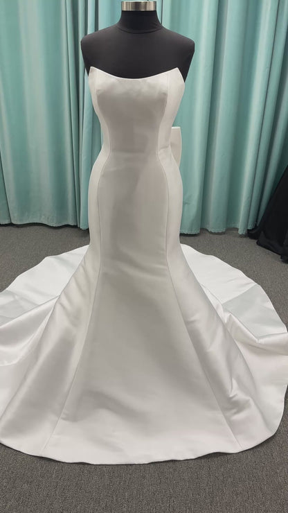 Strapless Mikado fit-and-flare wedding dress with sweetheart neckline, bow waist detail, and dramatic flared train by Stella York