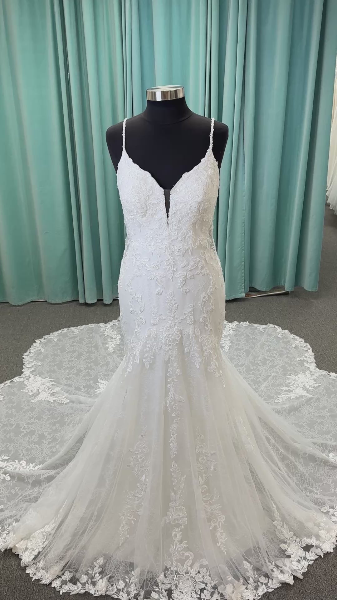 Starr ivory lace fit-and-flare wedding dress on mannequin with sweetheart neckline, delicate straps, and low open back with sweeping train.
