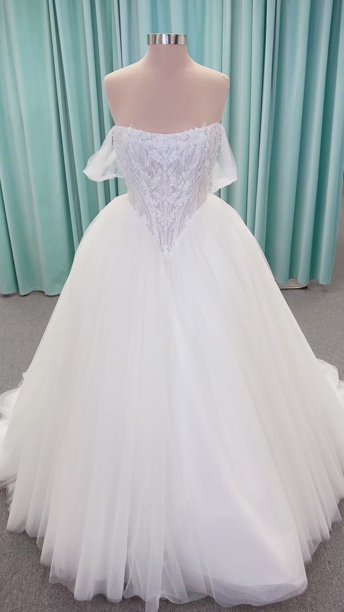 Morilee 1010036 Virtuoso ballgown wedding dress on mannequin with scoop neckline, off-the-shoulder tulle sleeves, beaded bodice, and lace-up corset back