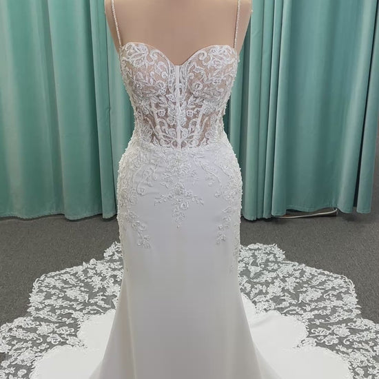 Liena ivory spaghetti strap wedding dress on mannequin with illusion corset bodice, floral lace appliqués, sweetheart neckline, and crepe skirt.
