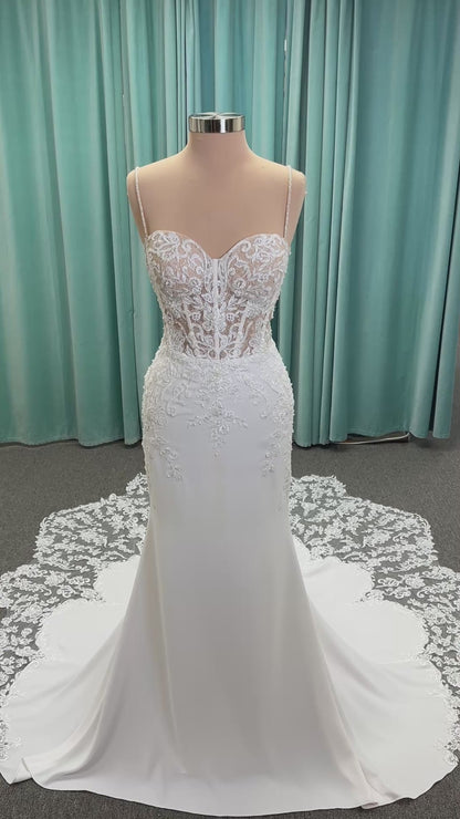 Liena ivory spaghetti strap wedding dress on mannequin with illusion corset bodice, floral lace appliqués, sweetheart neckline, and crepe skirt.
