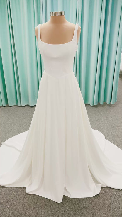 Stella York SY8180 A-line wedding dress on mannequin with wide straps, square neckline, contoured matte satin bodice, angled waist, and soft A-line skirt
