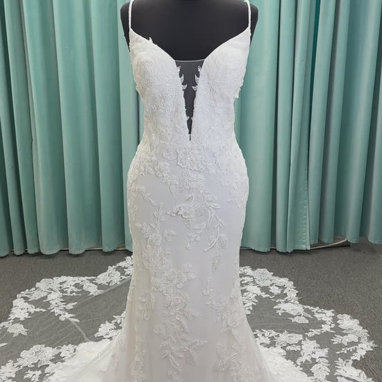 Gracie ivory long sleeve V-neck fit-and-flare wedding dress on mannequin with illusion lace sleeves, fitted silhouette, and scalloped lace cathedral train.
