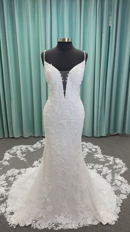 Gracie ivory long sleeve V-neck fit-and-flare wedding dress on mannequin with illusion lace sleeves, fitted silhouette, and scalloped lace cathedral train.
