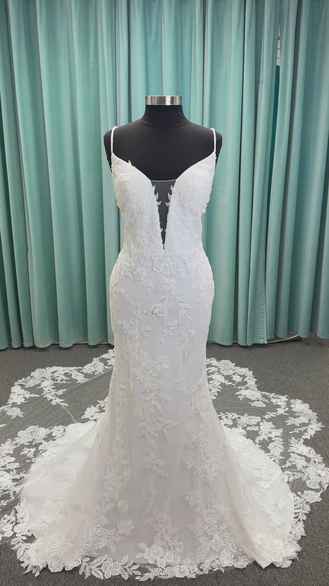 Gracie ivory long sleeve V-neck fit-and-flare wedding dress on mannequin with illusion lace sleeves, fitted silhouette, and scalloped lace cathedral train.
