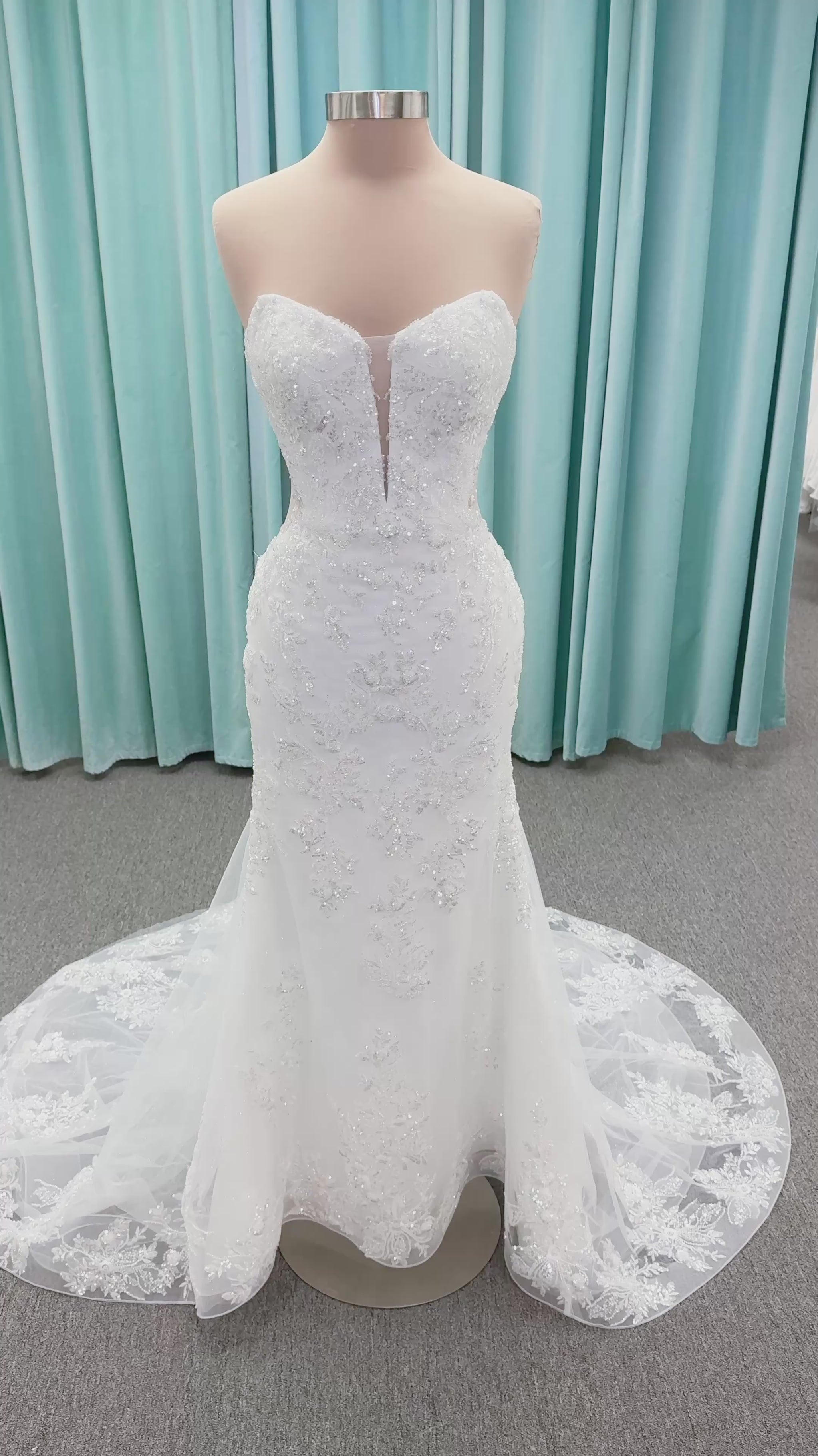 Moonlight Bridal J6996 Zira mermaid wedding dress on mannequin with strapless pointed sweetheart illusion neckline, side bodice cutouts, beaded lace appliques on shimmer net, drop waist, and chapel train with horsehair trim