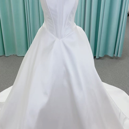 Randy Fenoli Idonna ball gown wedding dress on mannequin with strapless sweetheart neckline, structured mikado bodice, basque waist, covered back buttons, and side pockets