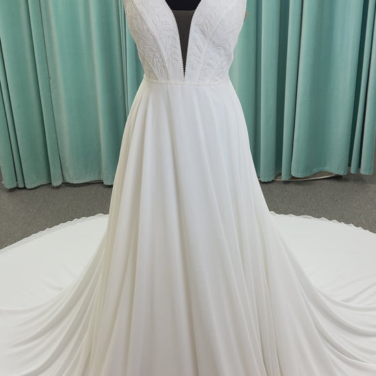Martha My Dear ivory sleeveless V-neck A-line wedding dress on mannequin with geometric lace bodice panel and flowing chiffon skirt.

