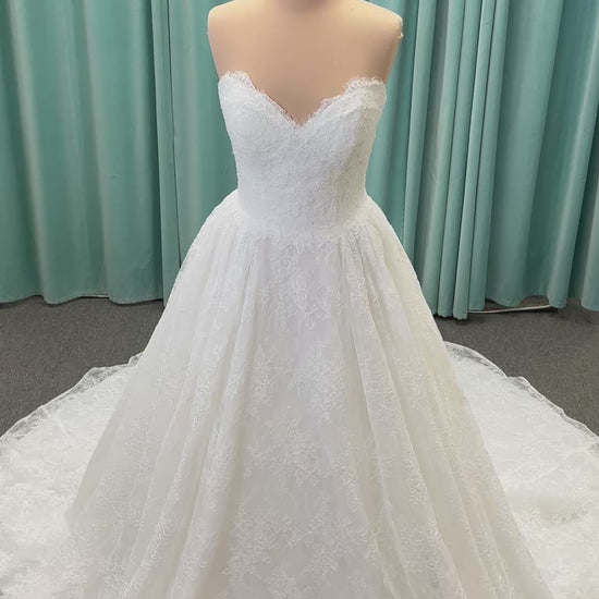 Moira ivory strapless sweetheart ballgown wedding dress on mannequin with sparkle lace detail and full voluminous skirt.
