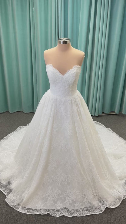 Moira ivory strapless sweetheart ballgown wedding dress on mannequin with sparkle lace detail and full voluminous skirt.
