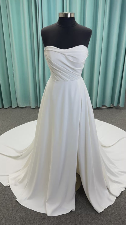 Essense of Australia D4225 ivory satin A-line wedding dress on mannequin with strapless scoop neckline, ruched bodice, and a front slit in the skirt.
