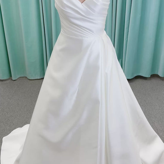 Moonlight Bridal J6852 Artemis A-line wedding dress on mannequin with strapless pointed sweetheart neckline, ruched mikado bodice, natural waist, pleated skirt with front slit, and sweep train