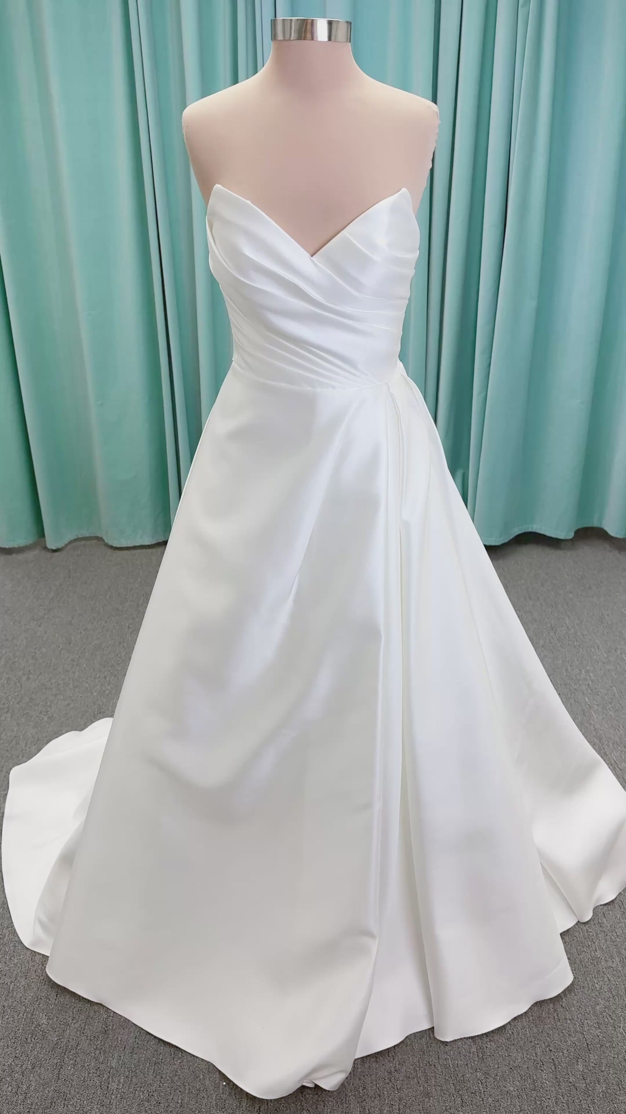 Moonlight Bridal J6852 Artemis A-line wedding dress on mannequin with strapless pointed sweetheart neckline, ruched mikado bodice, natural waist, pleated skirt with front slit, and sweep train