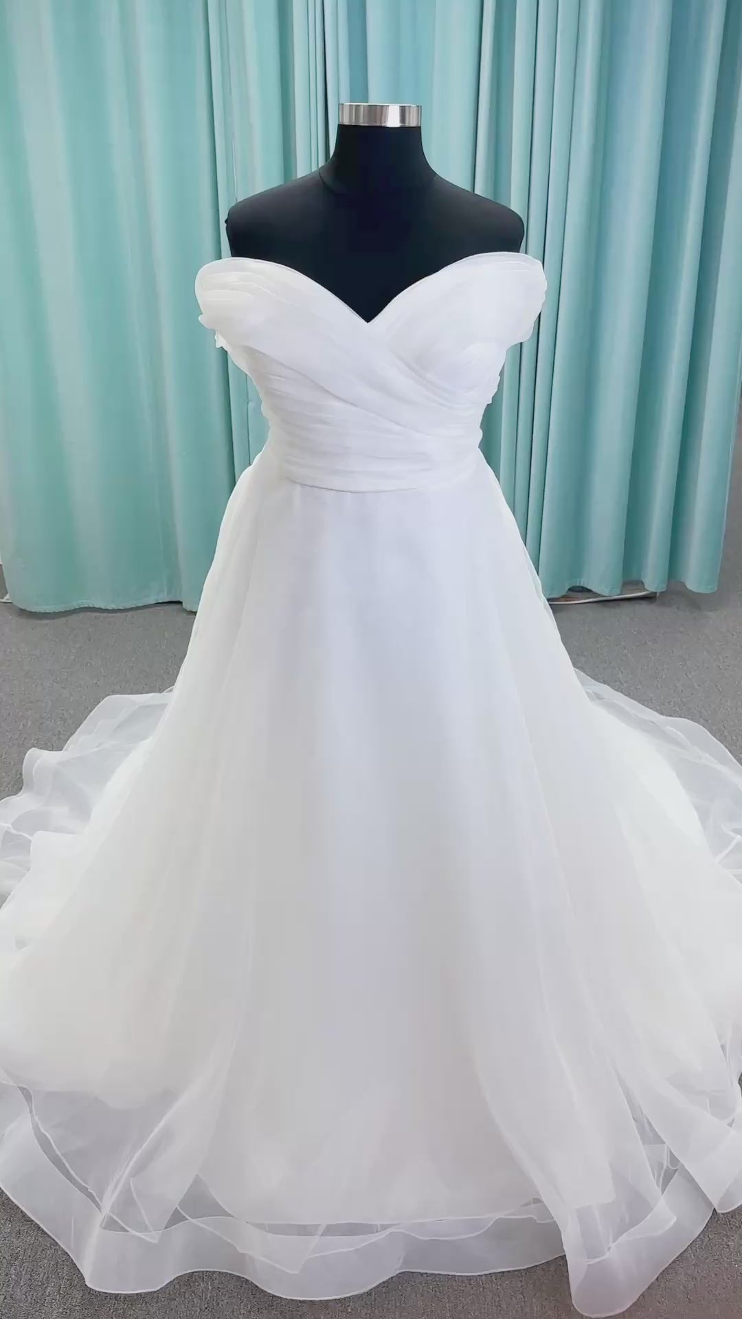 Morilee 3350 Evette ball gown wedding dress in draped organza with off-the-shoulder surplice bodice, horsehair-edged skirt, and covered buttons to hem.