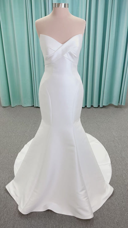 Randy Fenoli Imani fit and flare wedding dress on mannequin with strapless sweetheart neckline, structured mikado bodice, and oversized back bow with covered buttons