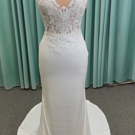 Calliope ivory spaghetti strap V-neck fit-and-flare wedding dress on mannequin with 3D floral lace appliqué bodice and sleek crepe skirt.
