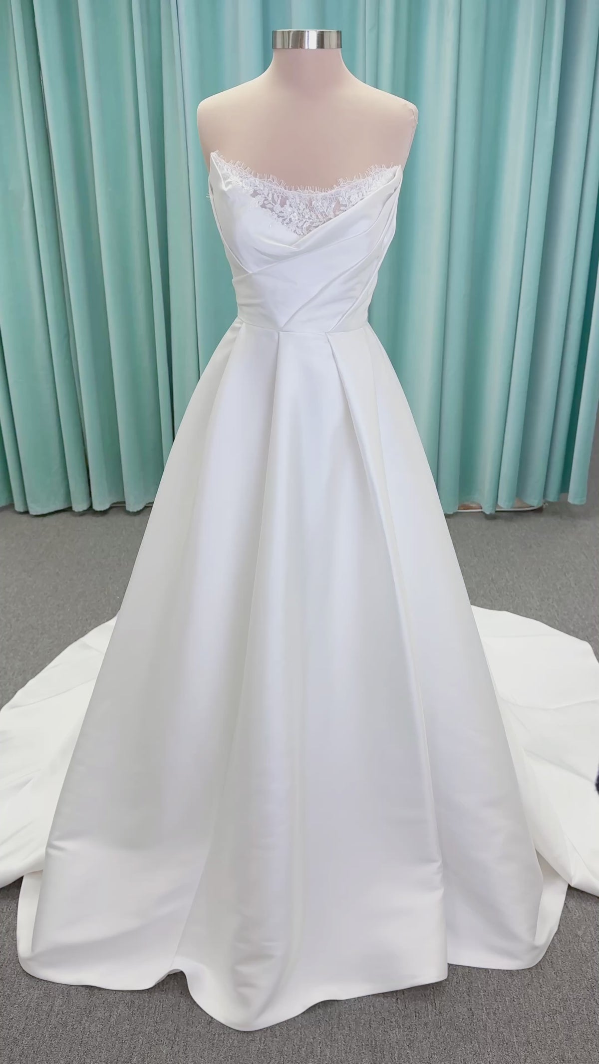 Morilee 1010001 Dove ballgown wedding dress on mannequin with strapless scoop neckline, lace peek-a-boo detail, and softly pleated skirt